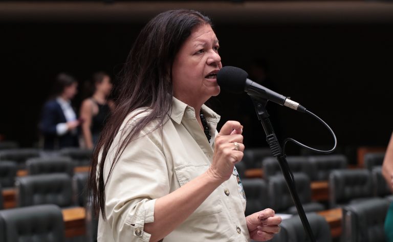 Assistente social analisando documentos em ambiente de trabalho, representando piso salarial da categoria