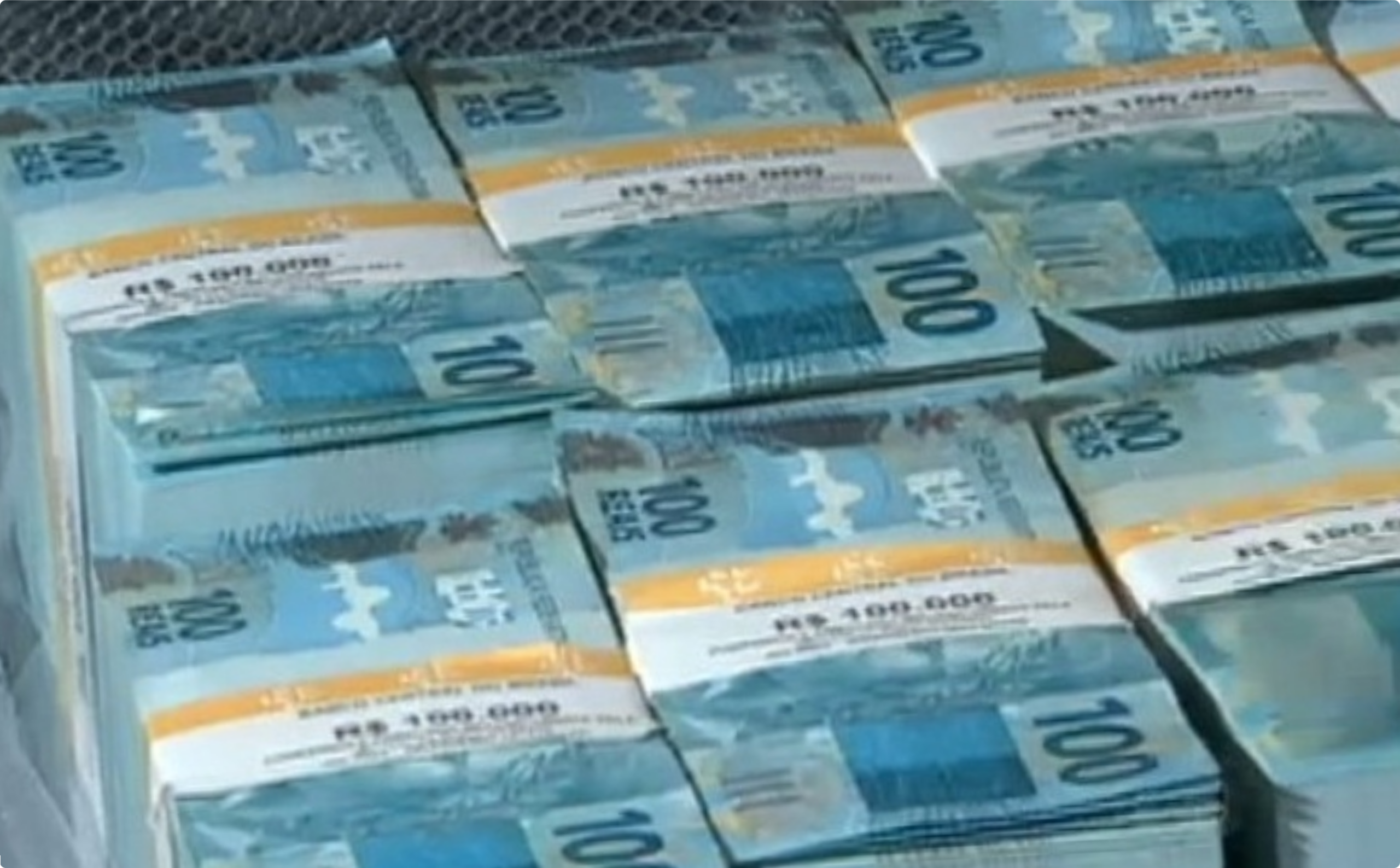 Vários maços de cédulas de 100 reais empilhados em feixes com lacres do Banco Central, representando o prêmio de R$ 100 milhões da Mega-Sena.