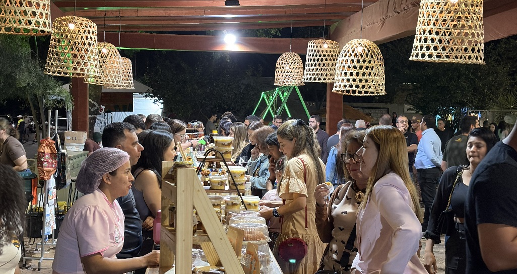 Público movimentando barracas de gastronomia regional com luminárias de palha no Festival Sabores do Gerais na Praça do Rotary.