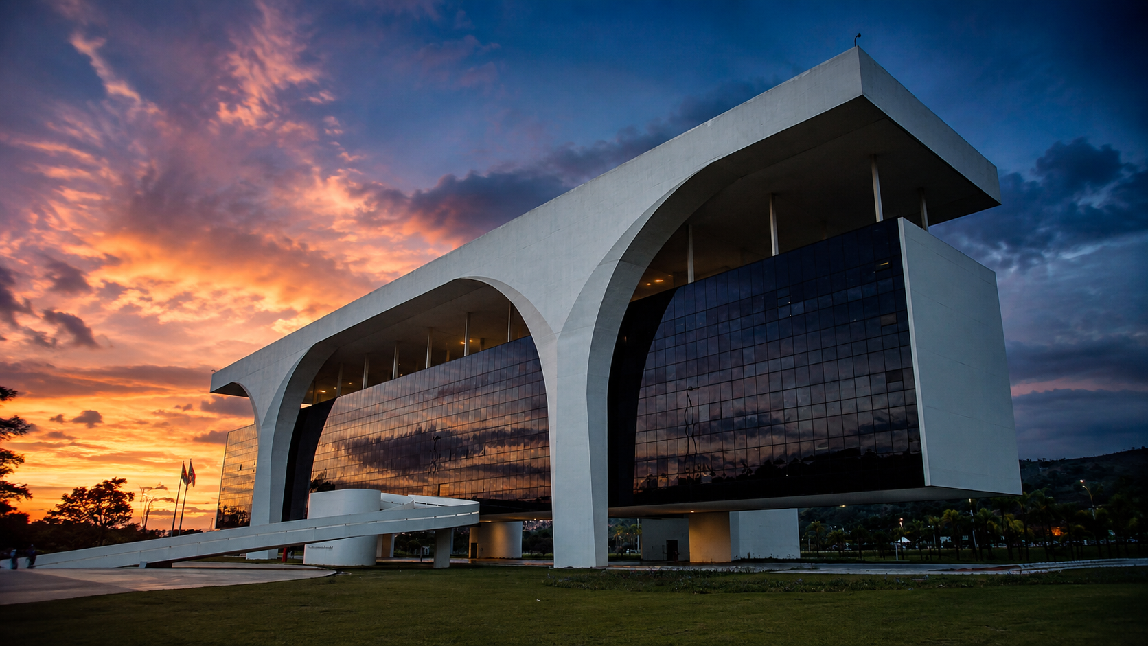 Vista frontal da Cidade Administrativa de Minas Gerais e do Palácio Tiradentes sob luz do fim de tarde.
